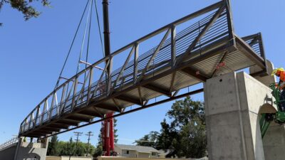 The pedestrian truss features H-section floor beams, a reinforced concrete deck and safety features designed to support long-term performance and user protection.