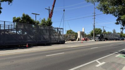 Bridge sections arrive on site and are prepared for assembly. The prefabricated weathering steel components were delivered in six sections, allowing for efficient on-site erection.