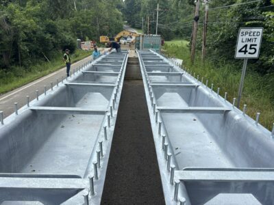 Close-up view of the galvanized U-24 press-brake tub girders, highlighting the trapezoidal steel sections, internal bracing and shear connectors prior to installation on the Geauga County bridge. Photo Credit: Nelson Bridge Systems